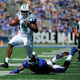 Quarterback Greg Windham #14 of the Ohio Bobcats slips past Dorance Armstrong Jr. #2 of the Kansas Jayhawks as he runs for a touchdown.